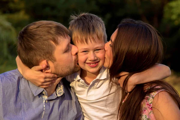 Kind mit Eltern, die sich umarmen und küssen. — Stockfoto