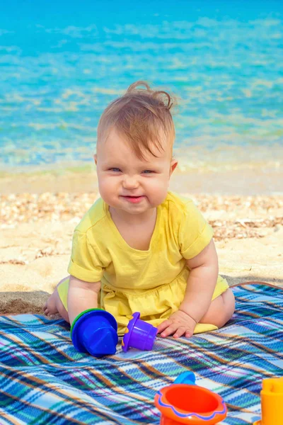 Lustiges Baby spielt am Strand. — Stockfoto