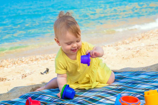 Lustiges Baby spielt am Strand. — Stockfoto