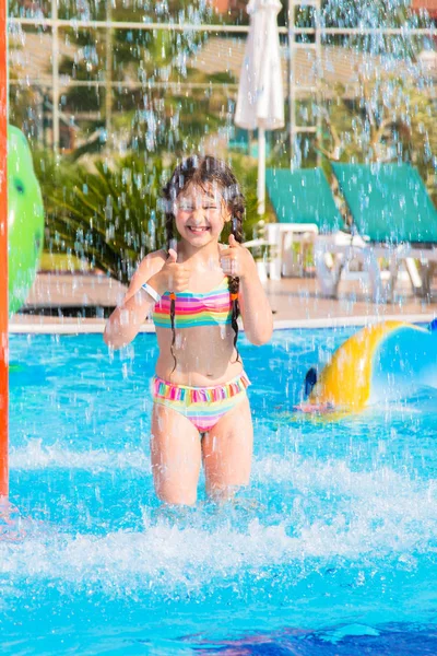 Chica mostrando pulgares hacia arriba en la piscina — Foto de Stock