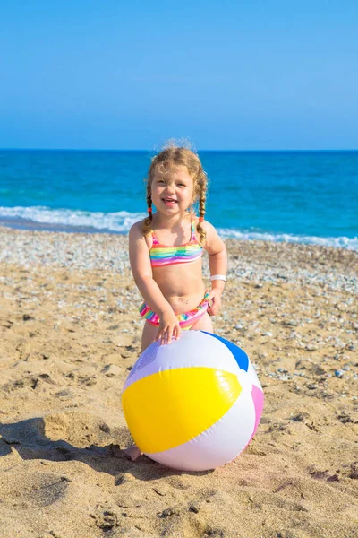 Enfant jouant avec le ballon sur la plage . — Photo