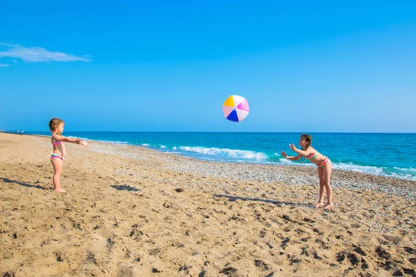 Kinderen spelen met een grote bal op het strand. — Stockfoto