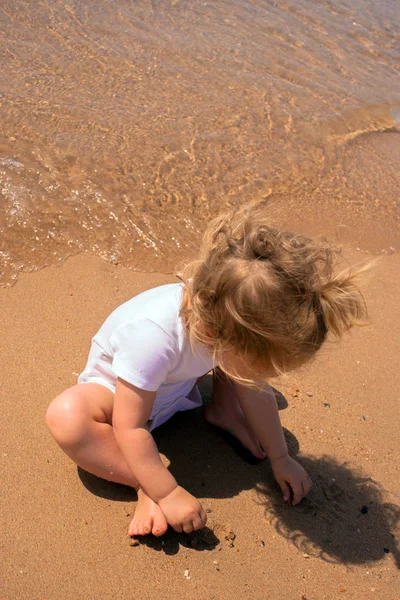 Bébé jouant avec le sable près de la mer — Photo