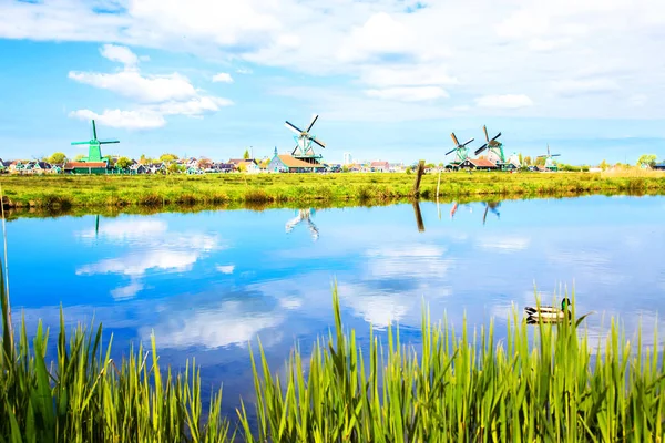 Floden och väderkvarnar. Reflektion av himlen — Stockfoto