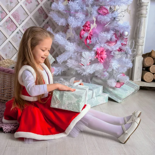 Ευτυχισμένη κοριτσάκι ανοίγει χριστουγεννιάτικα δώρα. — Φωτογραφία Αρχείου