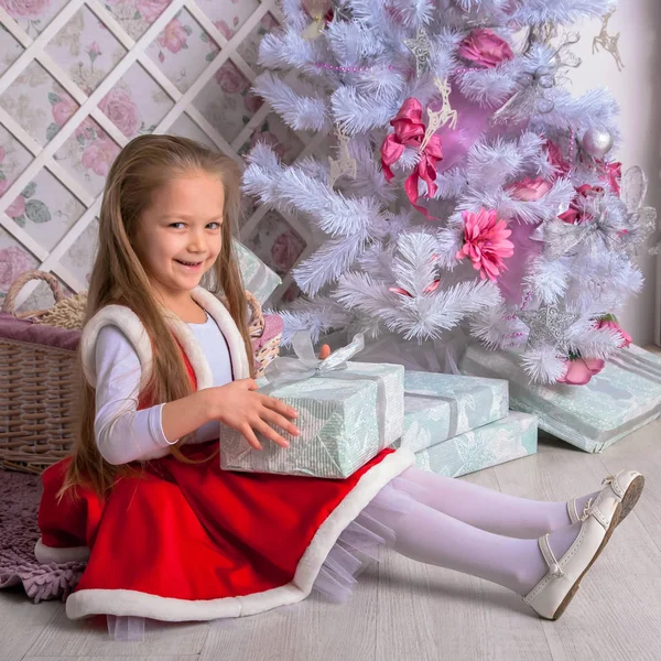 Bonne petite fille ouvre cadeaux de Noël . — Photo