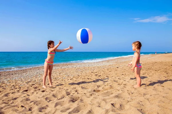 Crianças brincam com bola na praia . — Fotografia de Stock