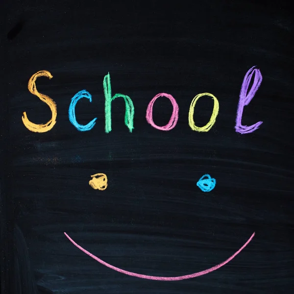 题字 "学校" 和微笑的面孔标志在黑板. — 图库照片