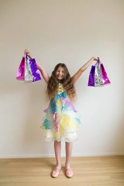 Fashion smiling little girl with shopping bags and gifts. — Stock Photo, Image