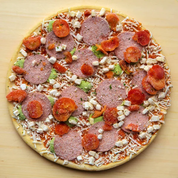 Frozen pizza "salami mozzarella pesto". Fast and junk food conce — Stock Photo, Image