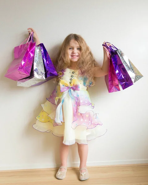 Linda menina sorridente com sacos de compras . — Fotografia de Stock