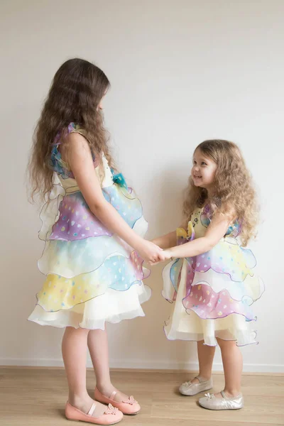 Zwei kleine Mädchen halten sich an den Händen und tanzen zusammen. — Stockfoto