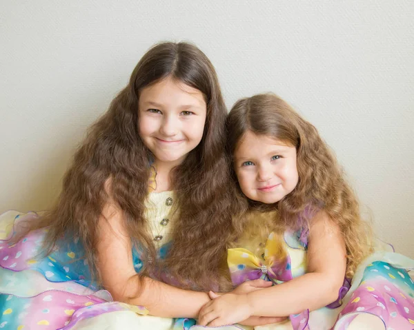 Duas garotas adoráveis com cabelos longos abraçando juntos . — Fotografia de Stock