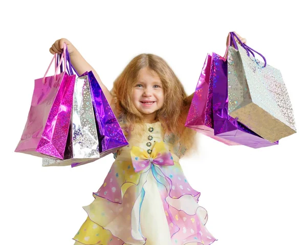 Ευτυχισμένος μικρό γελαστό κοριτσάκι με τσάντες αγορών. Απομονωμένα σε λευκό — Φωτογραφία Αρχείου