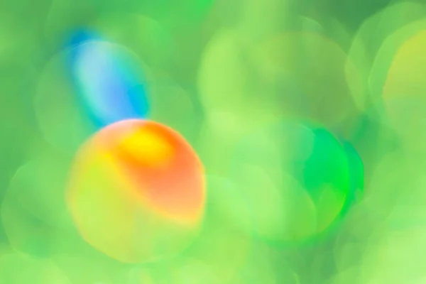 Blurred green background with colorful highlights. Bokeh. — Stock Photo, Image
