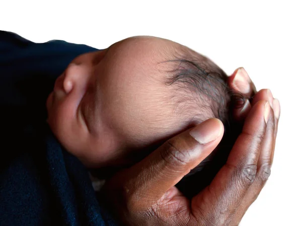 Zwarte vader die het hoofd pasgeboren baby in zijn handen. — Stockfoto