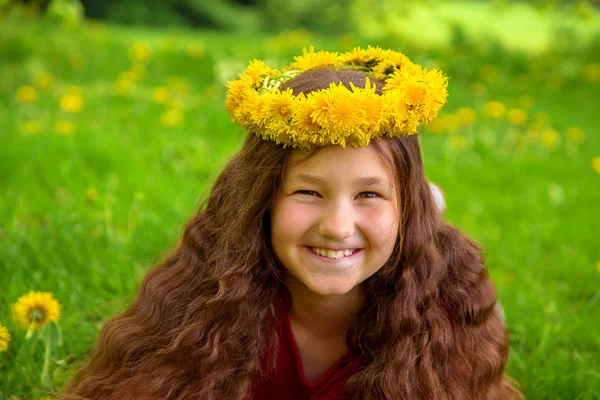 Fille souriante aux longs cheveux bruns en couronne de pissenlits — Photo