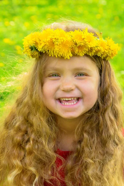 Smiling baby girl with long blond hair wearing crown of dandelio — Stock Photo, Image