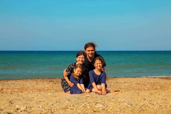 Retrato de família sorridente na praia contra o mar . — Fotografia de Stock