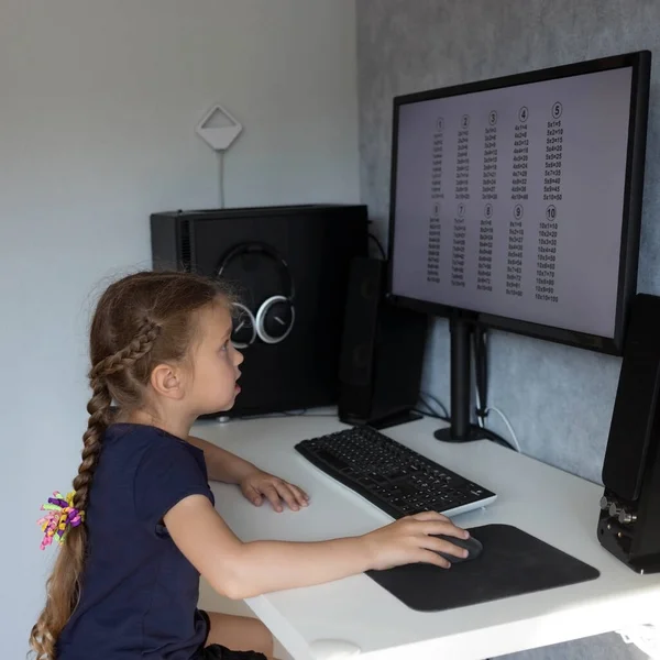 家庭教育 小さな女の子は 親コンピュータ上の自宅で乗算テーブルを学習します 家庭教育 コロナウイルスのパンデミック — ストック写真