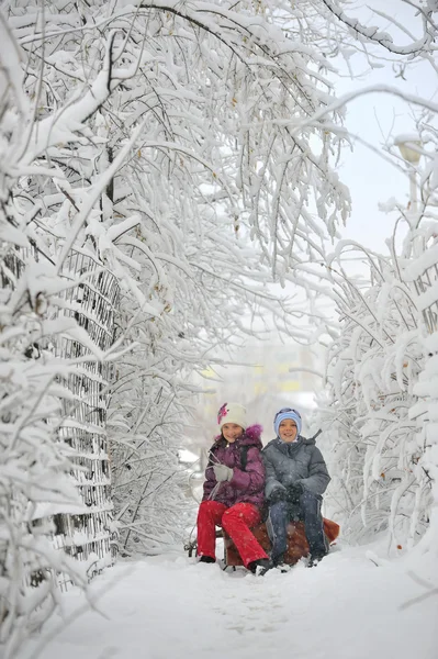 Due bambini scorrevoli con slittino — Foto Stock