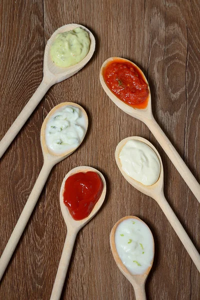 Different types of sauces in spoons — Stock Photo, Image