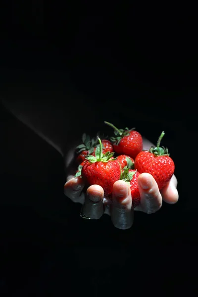 Frau hält Palme voller Erdbeeren in der Hand — Stockfoto
