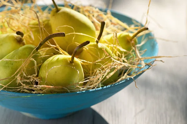 Ripe pears in a basket on wooden table — Stock Photo, Image