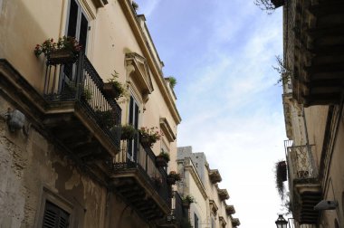 Lecce 'un büyüleyici sokakları. Mavi gökyüzüne karşı balkon çiçeği. Lecce, Puglia, İtalya