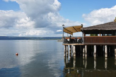 Bolsena Gölü manzarası. Arka planda ahşap işçiliği olan tipik bir restoran. Bolsena, Lazio, İtalya