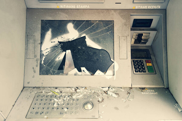 Damaged, vandalised, abandoned ghost ATM, out of order destroyed cash machine. Front view of broken, out of service auto teller machine with cracked screen. Financial and economic crisis. Regression.