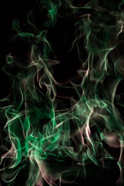 Yeşil ateş siyah arkaplanda soyutlama oluşturur