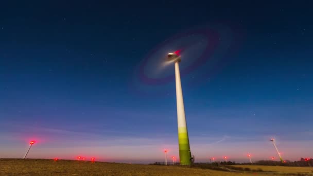 A szélturbina gyorsan forog az éjszakai égbolton Litvániában, Európában — Stock videók