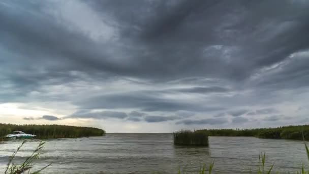 Wietrzny dzień z burzowymi chmurami nad jeziorem — Wideo stockowe