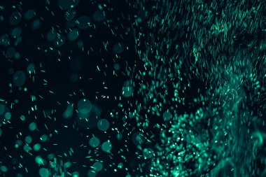 Yeşil ateş siyah arkaplanda kor soyutlaması oluşturur