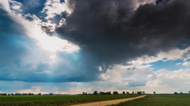 Облако одной штормовой ячейки с солнечными лучами, образующимися над полями — стоковое видео