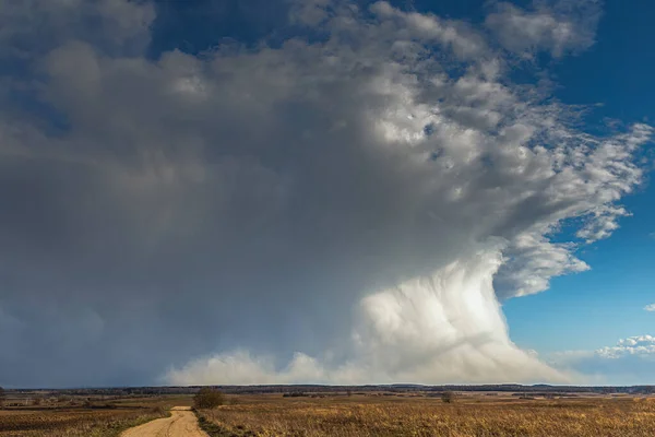 Path to cumulonimbus with snow streaks at sunset, beautiful landscape — Stock Photo, Image