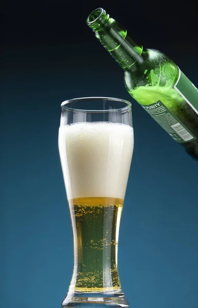 Bottle and glass filled with beer with foam