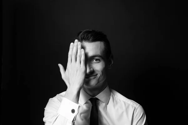 Bir beyaz gömlek ve siyah kravat, yarım yüz, siyah arka plan karşı kapsayan el genç bir adam portresi siyah ve beyaz