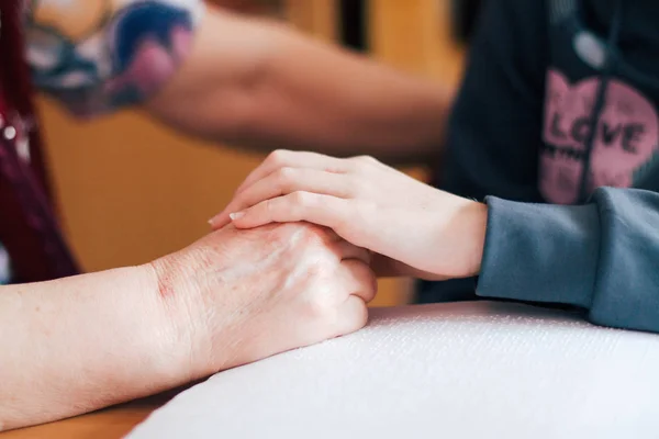 Yardım ve güven. Yetişkinler el ele tutuşur.