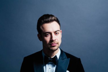 Bir takım, dramatik genç yakışıklı bir adam portresi aydınlatma, kamera düz studio arka plan karşı ciddi görünümlü