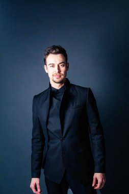 Ayakta, ciddi ve kamera düz studio arka plan bakarak bir takım, yakışıklı bir genç adam portresi.