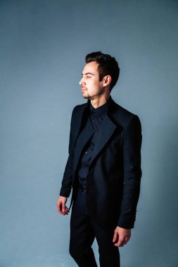 Düz studio arka plan karşı tarafa arayan genç yakışıklı bir adam bir takım, portresi