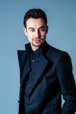 Ayakta ve kamera düz studio arka plan bakarak bir takım, yakışıklı bir genç adam portresi.