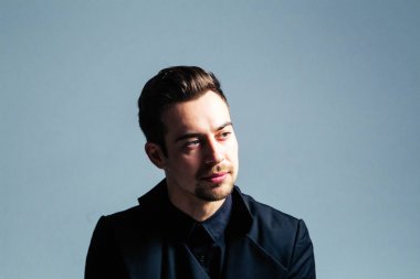 Düz studio arka plan karşı tarafa arayan genç yakışıklı bir adam bir takım, portresi