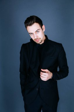 Ayakta ve kamera düz studio arka plan bakarak bir takım, yakışıklı bir genç adam portresi.