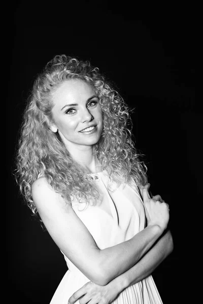 Portrait of a pretty curly blonde woman, wearing light dress