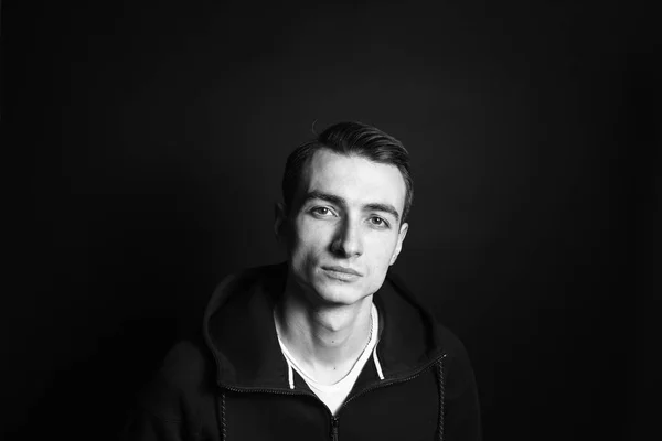 Black and white portrait of a young man in a black sweatshirt
