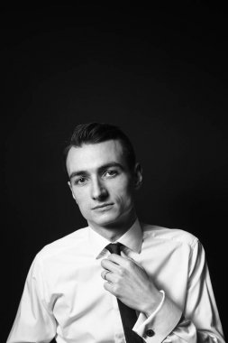 Beyaz gömlekli ve siyah kravatlı bir gencin portresi.
