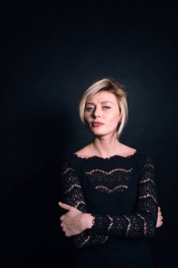 Kamerayı düz studio arka plan bakarak bir siyah dantel elbise genç bir kadın portresi kapatın